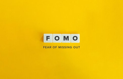 FOMO spelled out in letter tiles on a yellow background