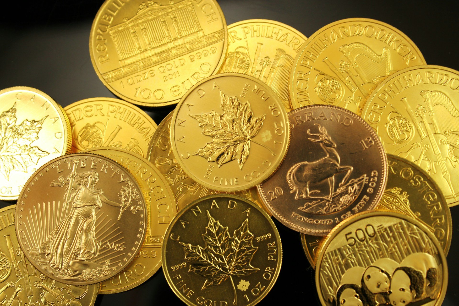 Stack of physical gold bullion coins from various mints