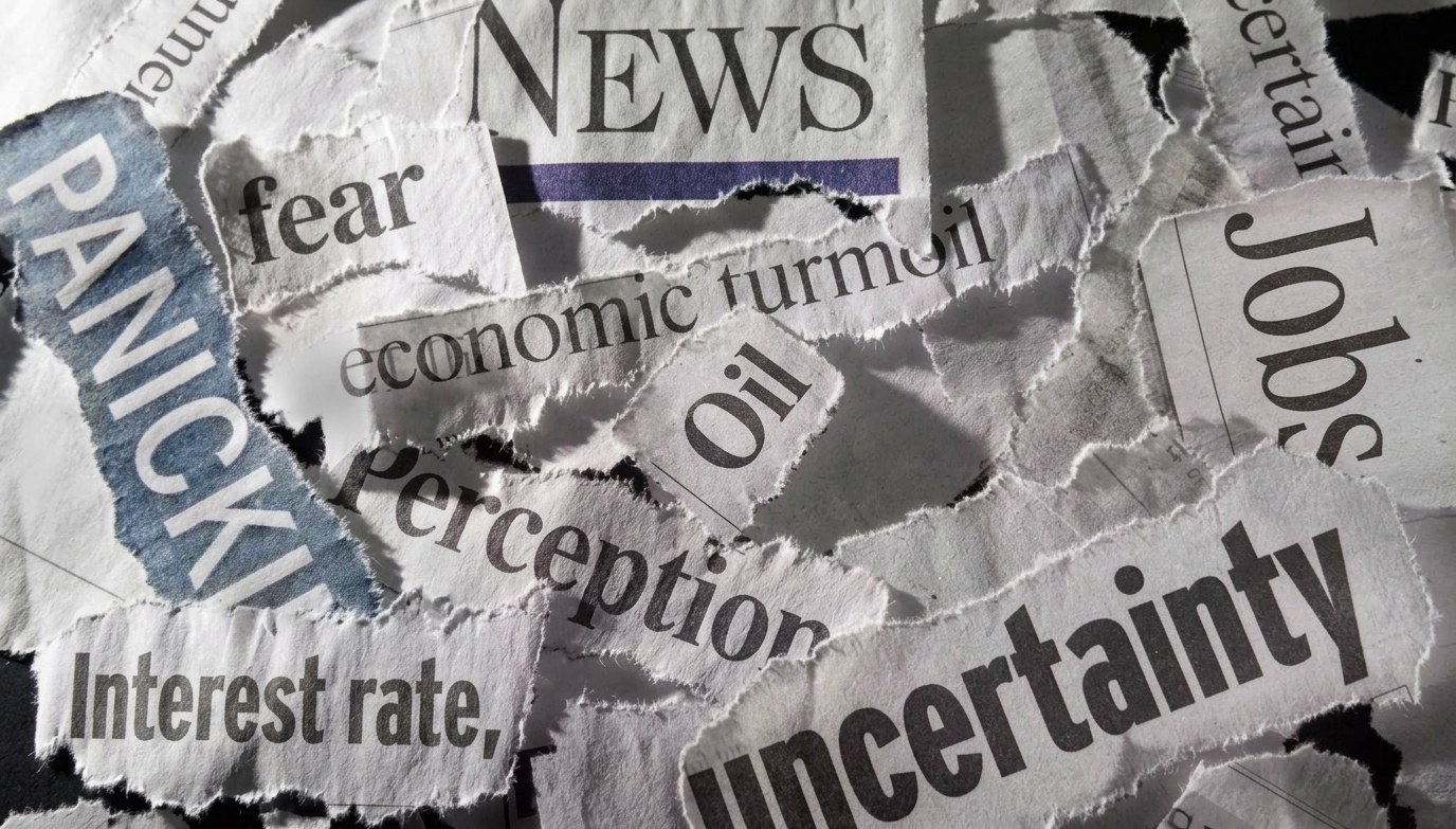 Torn newspaper headline fragments reading PANIC, fear, uncertainty, economic turmoil